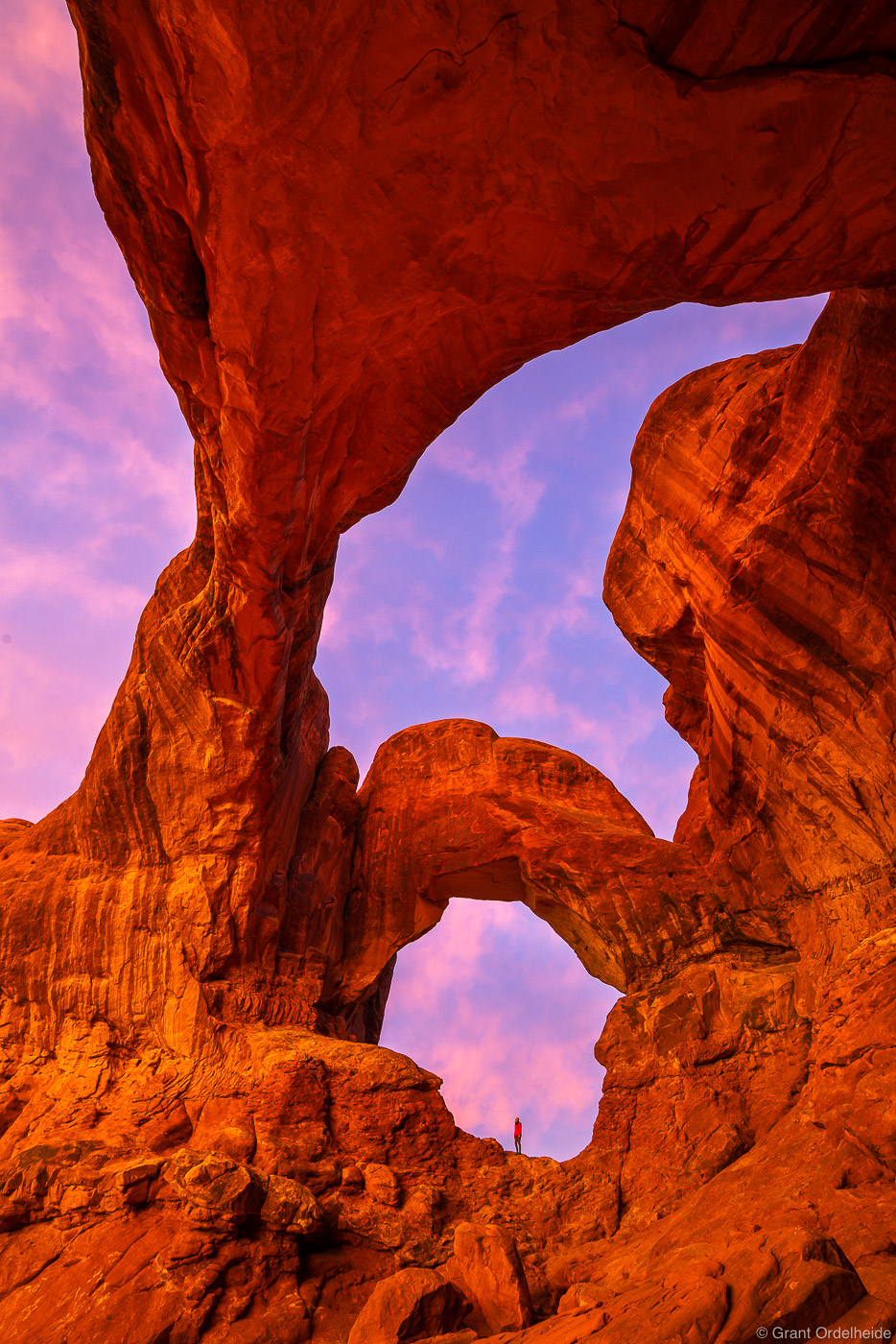 Pink sunrise over Double Arch in Arches National Park near Moab, Utah.