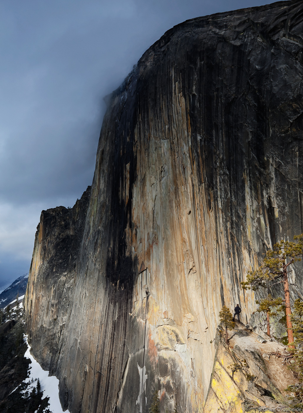 A person on the Diving Board next to the impressive face of Half Dome in Yosemite.