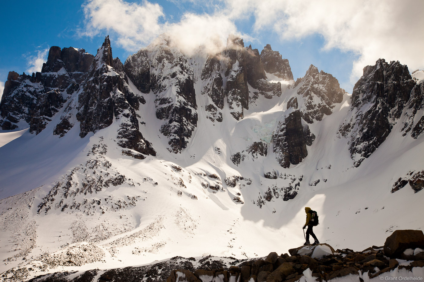 A climber stands below the rugged Cerro Sahne Nuss and the surrounding, unnamed peaks.