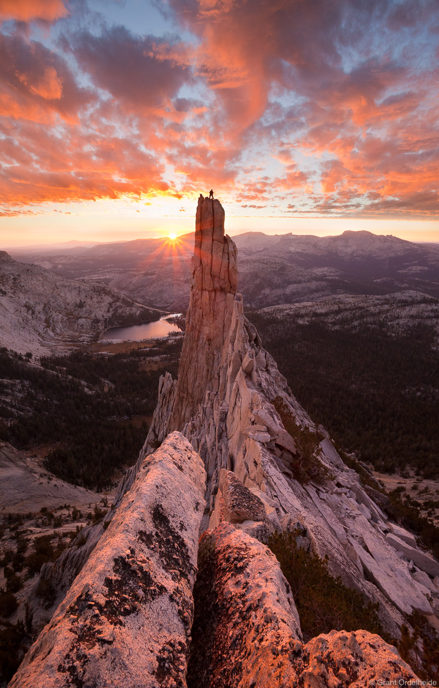 A climber stands atop the striking granite tower known as Eichorn Pinnacle. The pinnacle which lies on the western flank of Cathedral...