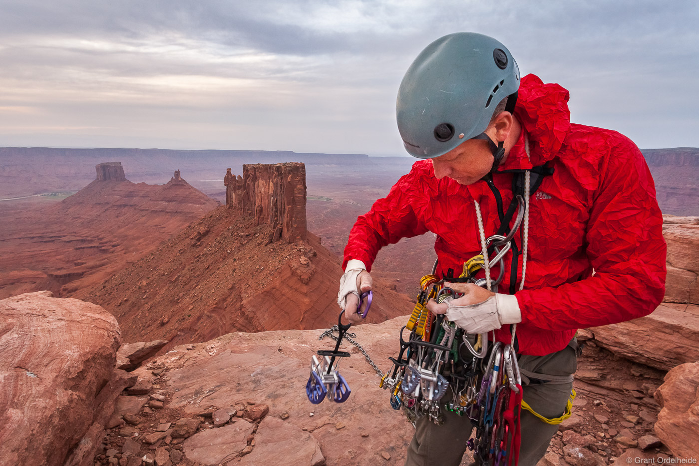 A climber racking up his cams after climbing the North Chimney (5.8) on Utah's Castleton Tower.