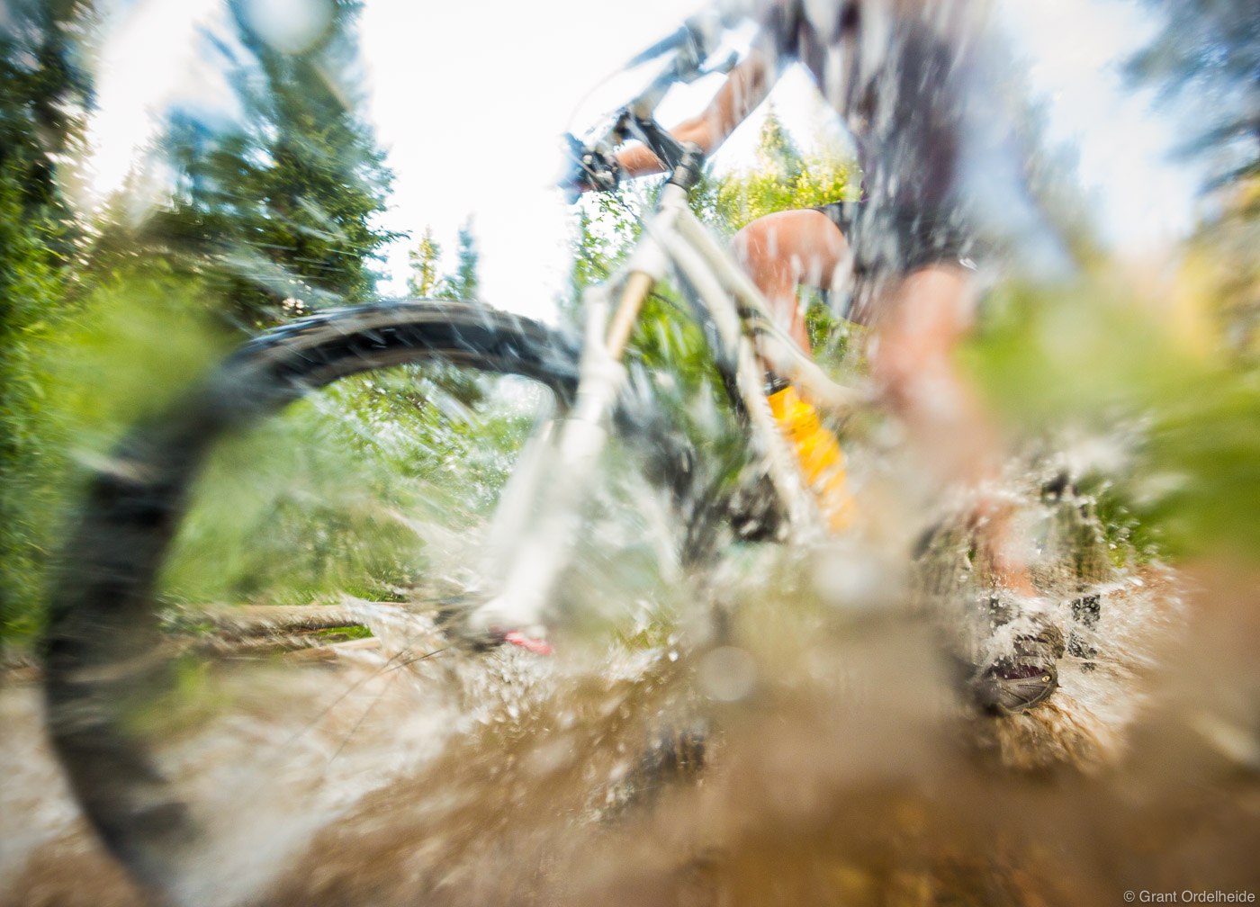Mountain biking through a stream on a trail near the town of Winter Park, Colorado.