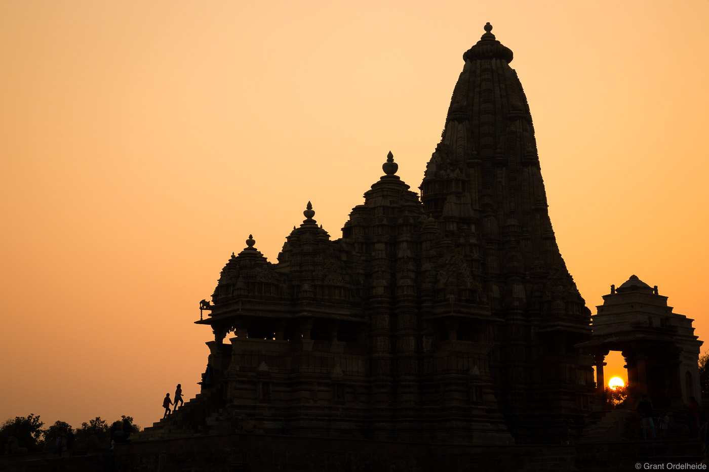 A couple of people ascend a staircase into one of the Lakshmana Temple, a Hindu temple in Khajuraho India.