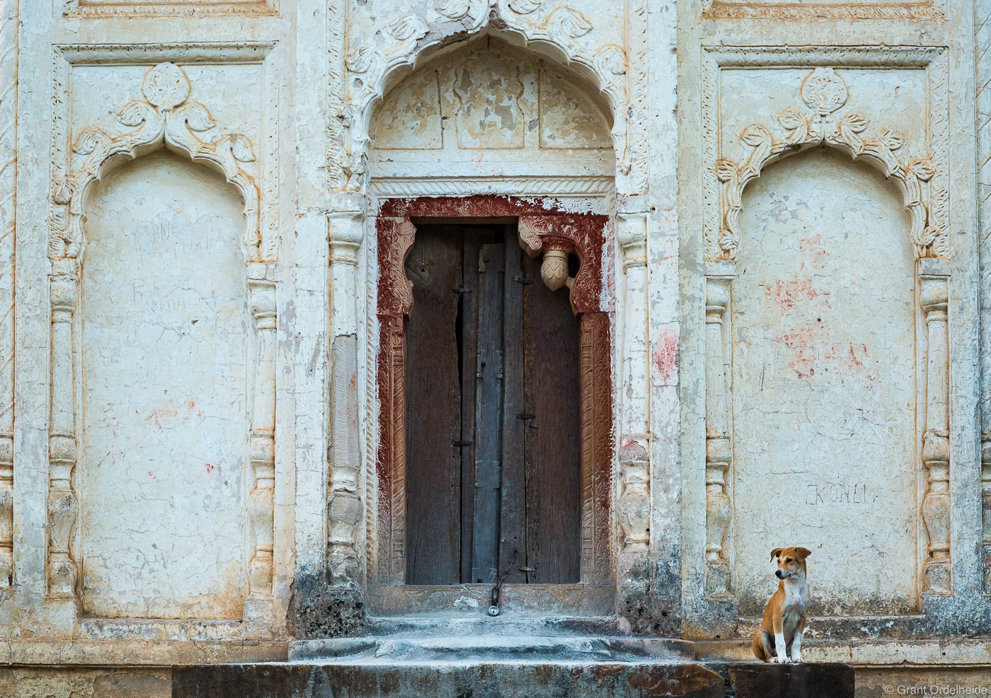 A stray dog stands guard at the entrance of one of the Lakshmana Temples.