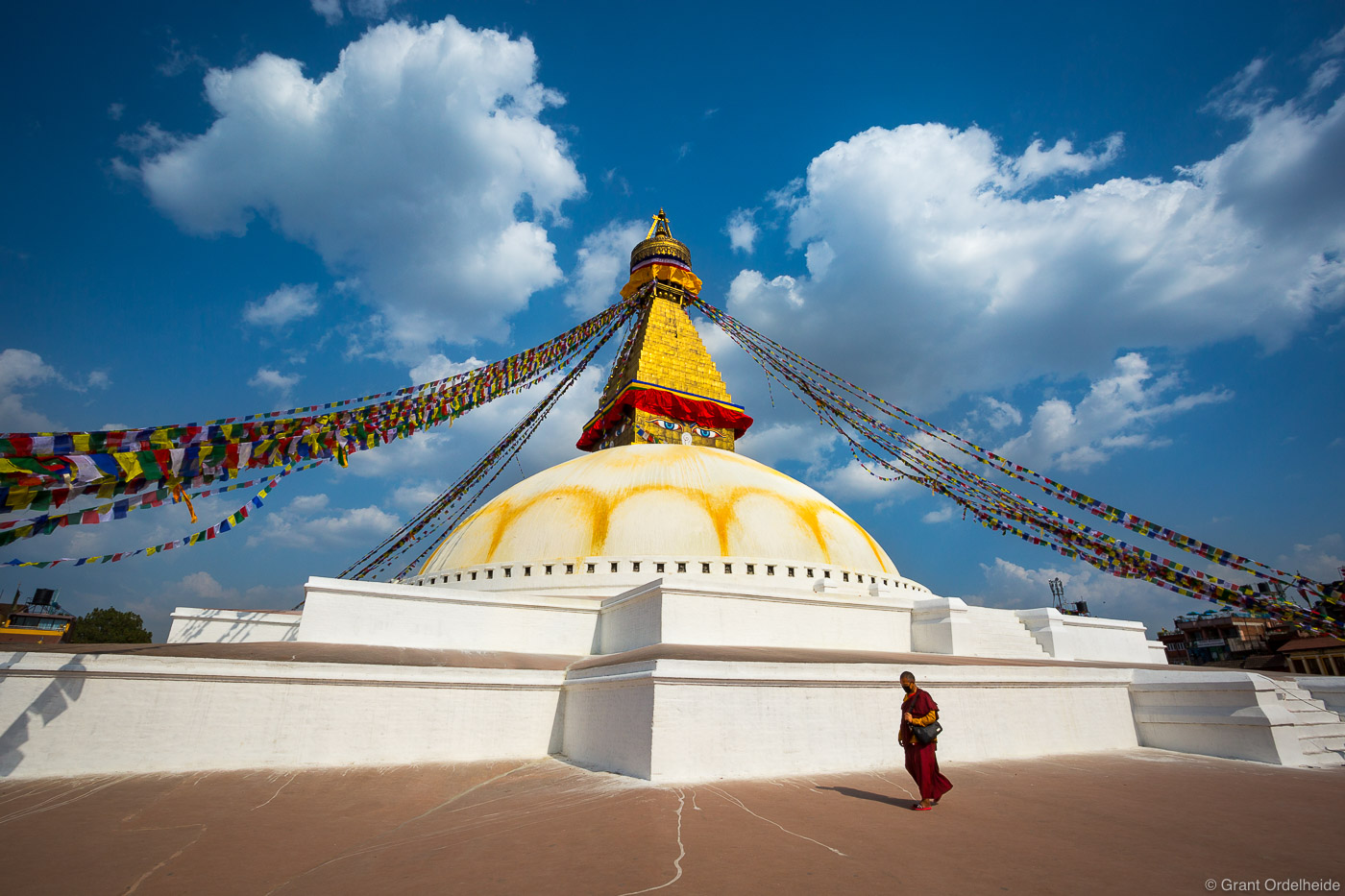 A Bhuddhist monk walks around Bodhnath Stupa in Katmandu Nepal.