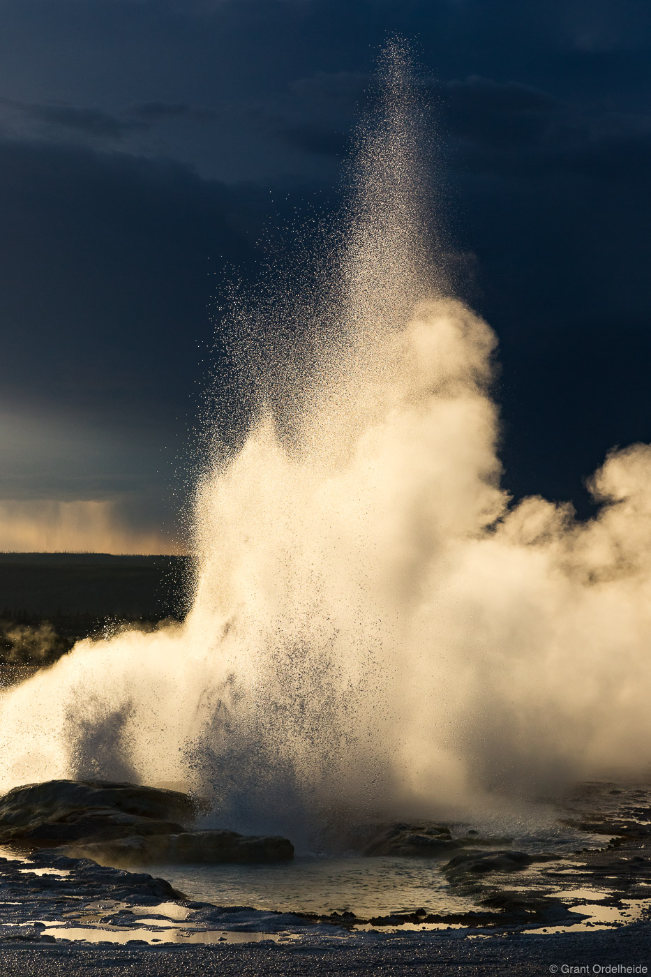 Clepsydra Geyser erupting below an impending summer storm.