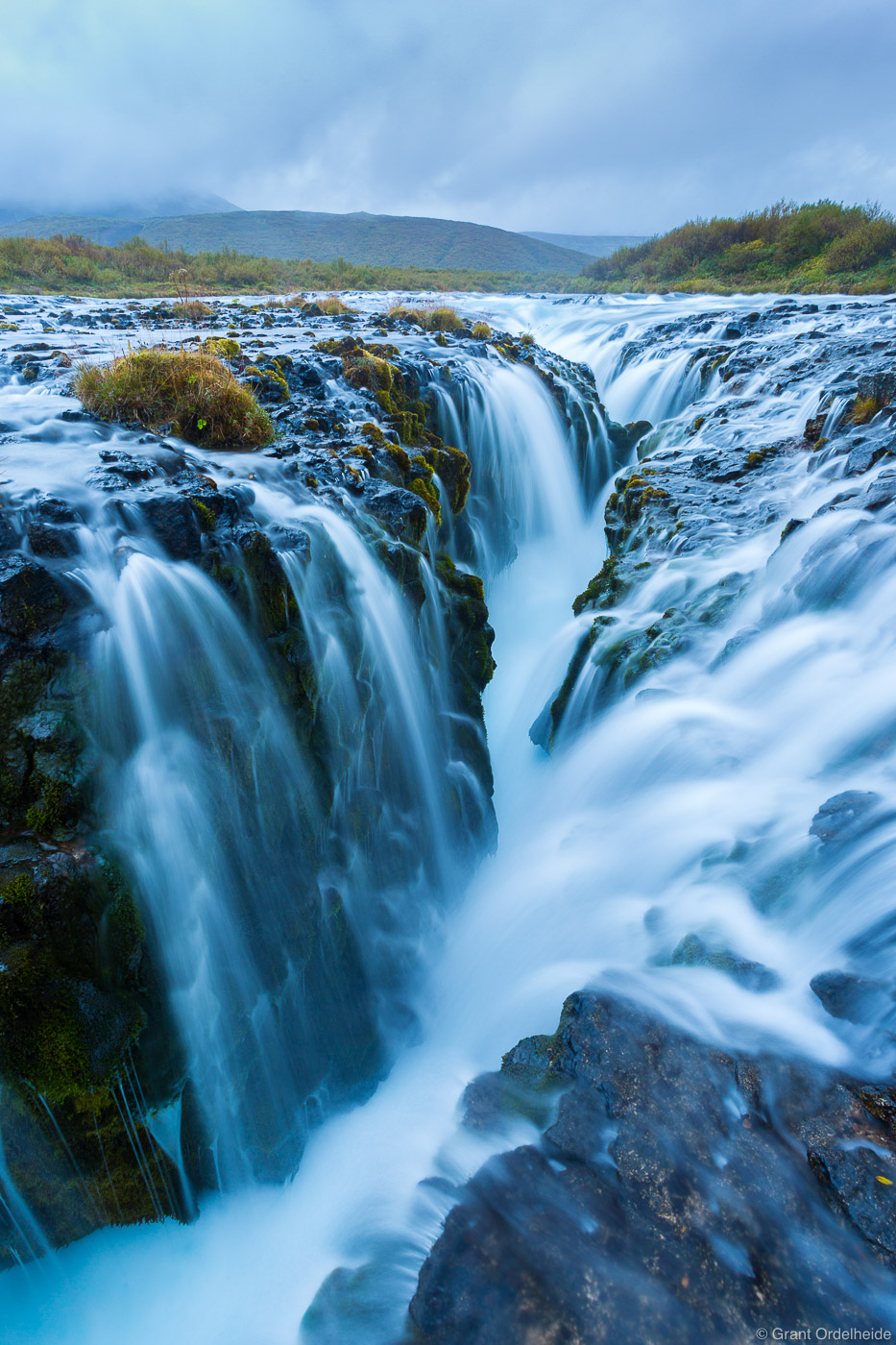 Water pouring into an ancient volcanic rift creating the Brúarfoss waterfall.