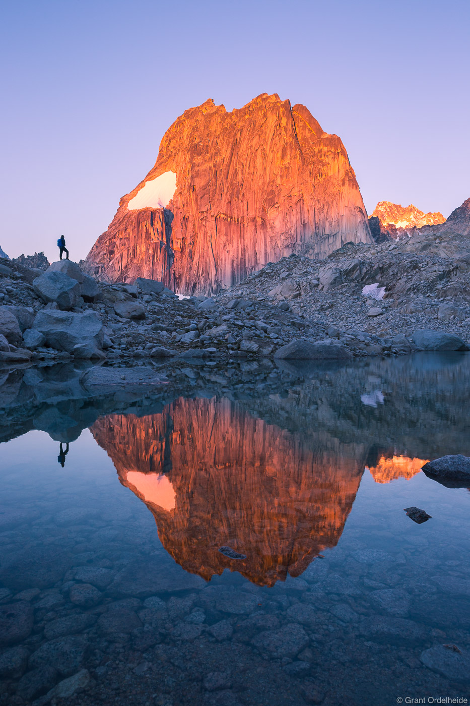 A climber watches sunrise&nbsp;on&nbsp;the massive Snowpatch Spire&nbsp;in Bugaboo Provincial Park.