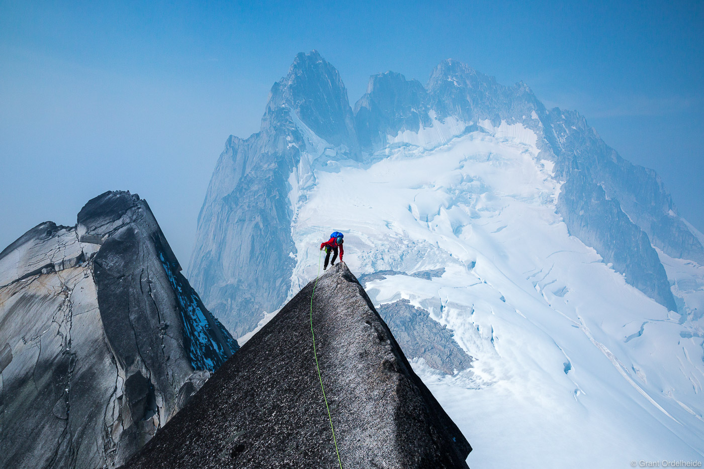 A climber&nbsp;makes his way up the iconic West Ridge of Pigeon Spire with the Howser Towers in the background in Canada's Bugaboo...