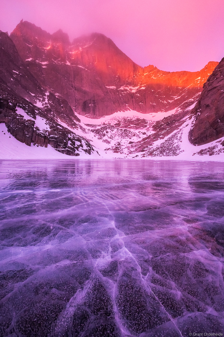 A stormy morning above a frozen Chasm Lake and The Diamond Face of Longs Peak in Rocky Mountain National Park.
