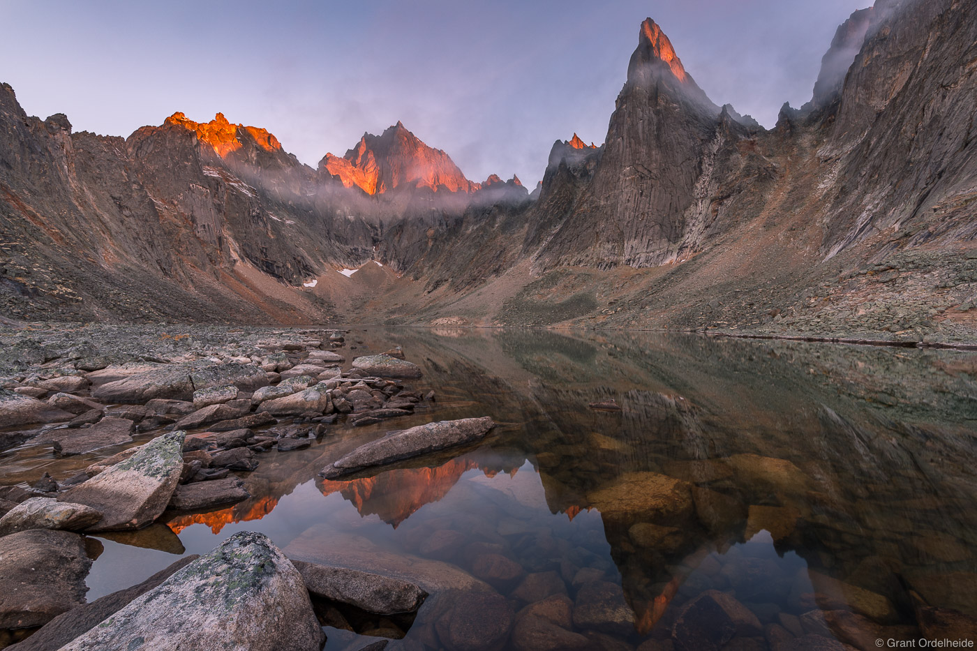 Sunrise over some rugged peaks from a&nbsp;remote lake&nbsp;in Tombstone Territorial Park.