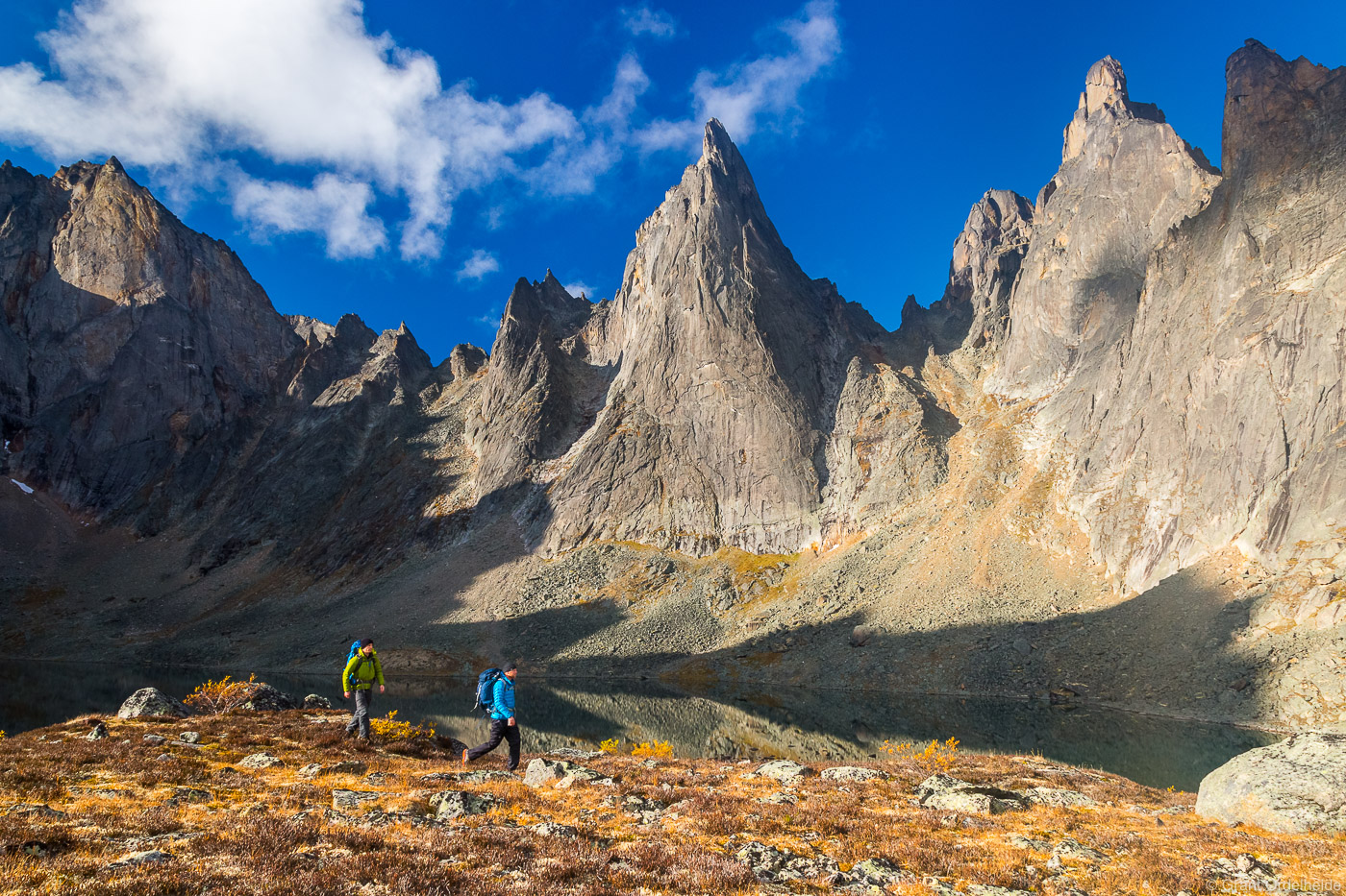 A pair of backpackers below rugged peaks deep in the backcountry of Tombstone Territorial Park located in Canada's Yukon Territory...