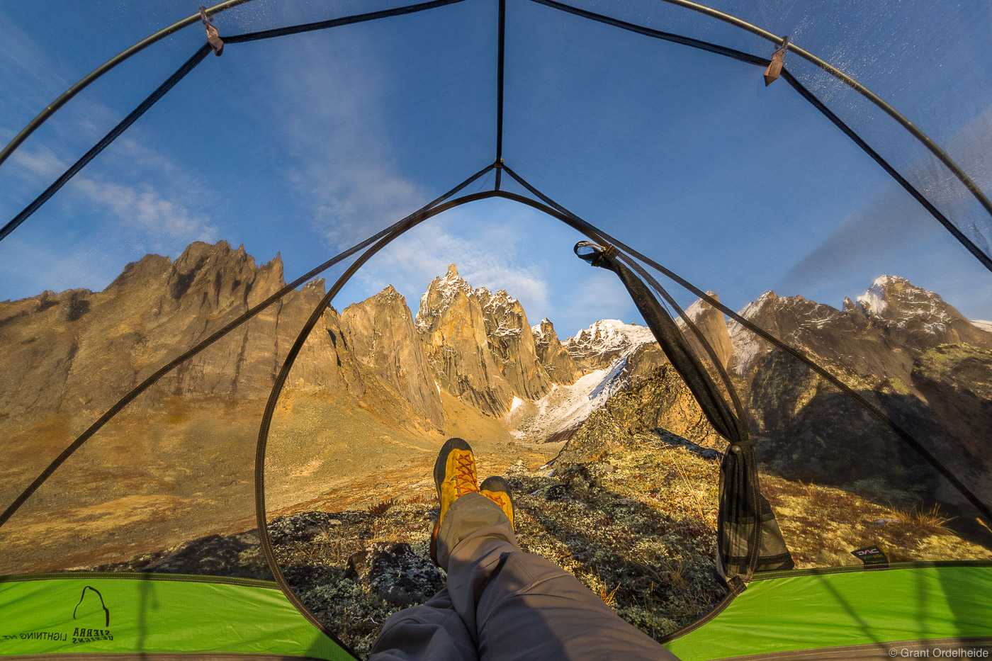 A backpacker enjoying the view of Mount Monolith from his tent.
