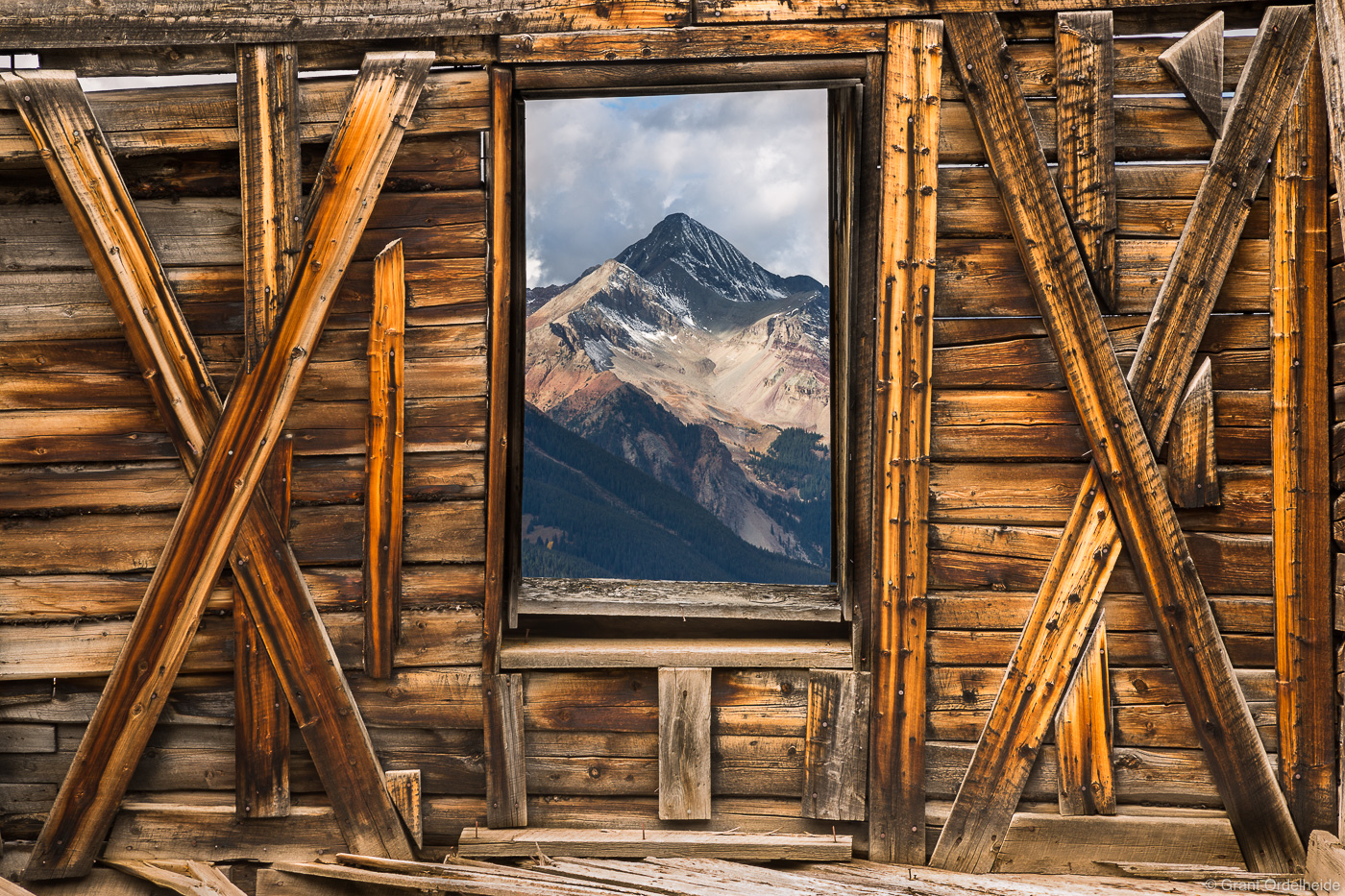 Wilson Peak, a fourteen thousand foot peak, viewed through a window in a dilapidated building at Alta Lakes ghost town above...