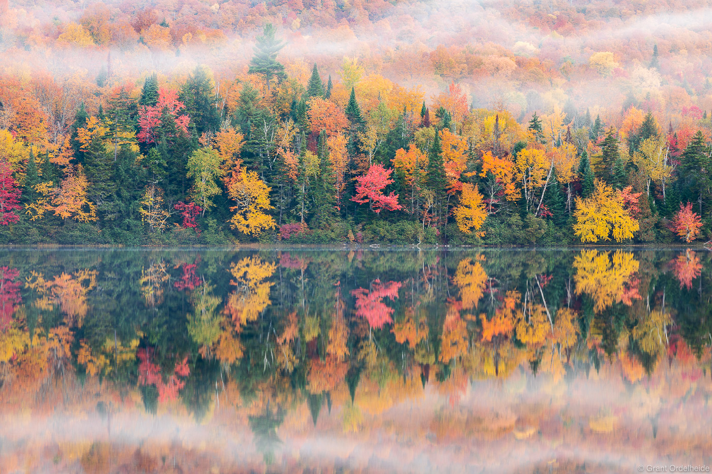 A kaleidoscope of fall colors refelcted in a small pond located in the Adirondack Mountains of Upstate New York.