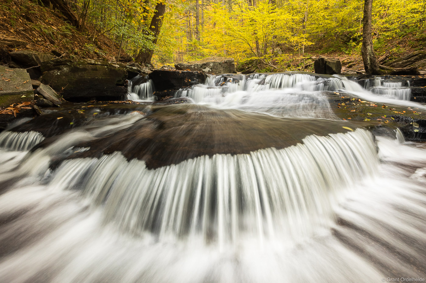Fall foliage and cascading waterfalls in Pennsylvania's Ricketts Glen State Park.