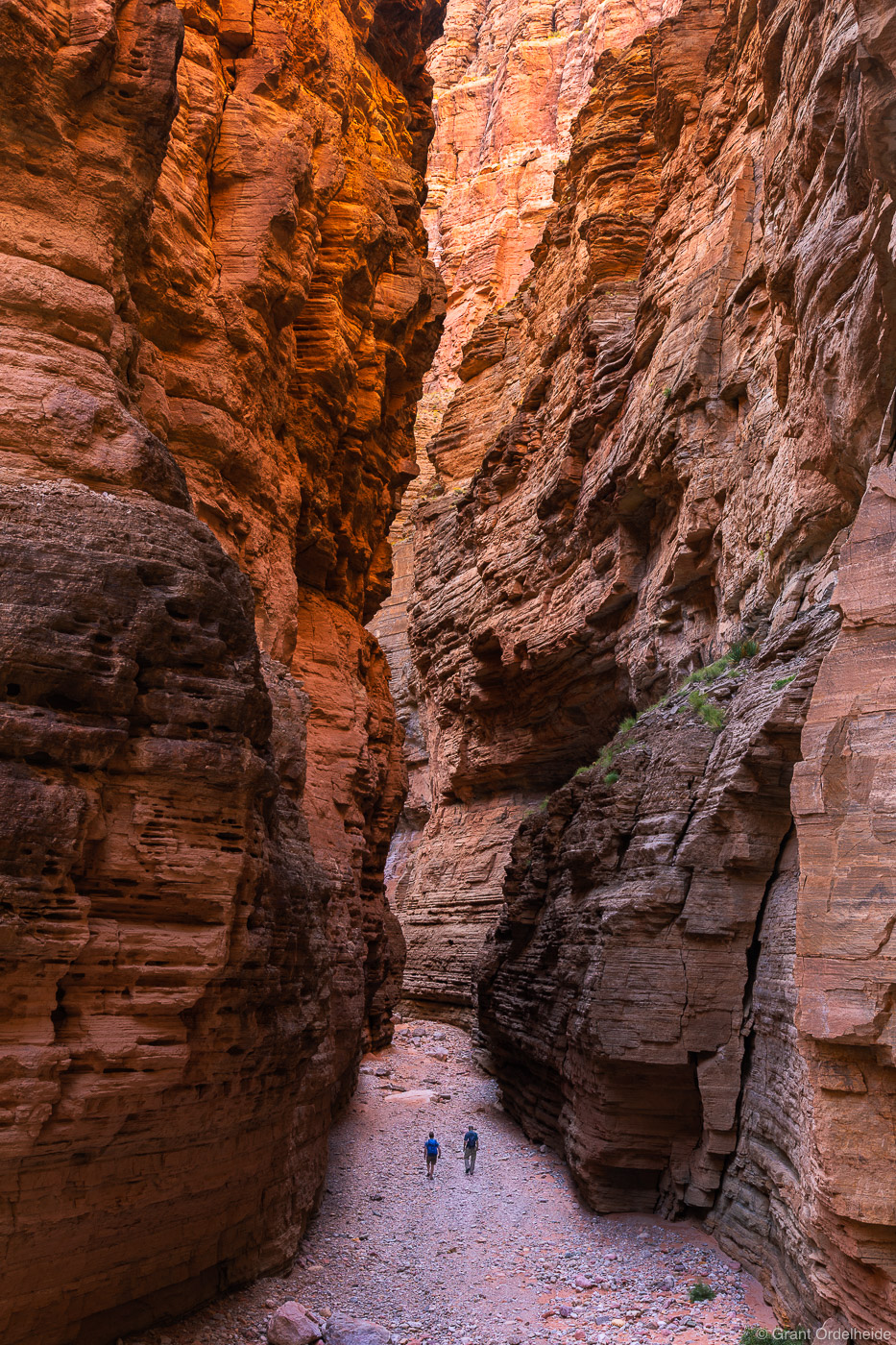 A couple of hikers dwarfed by Fern Glen Canyon, a side canyon of the Grand Canyon.
