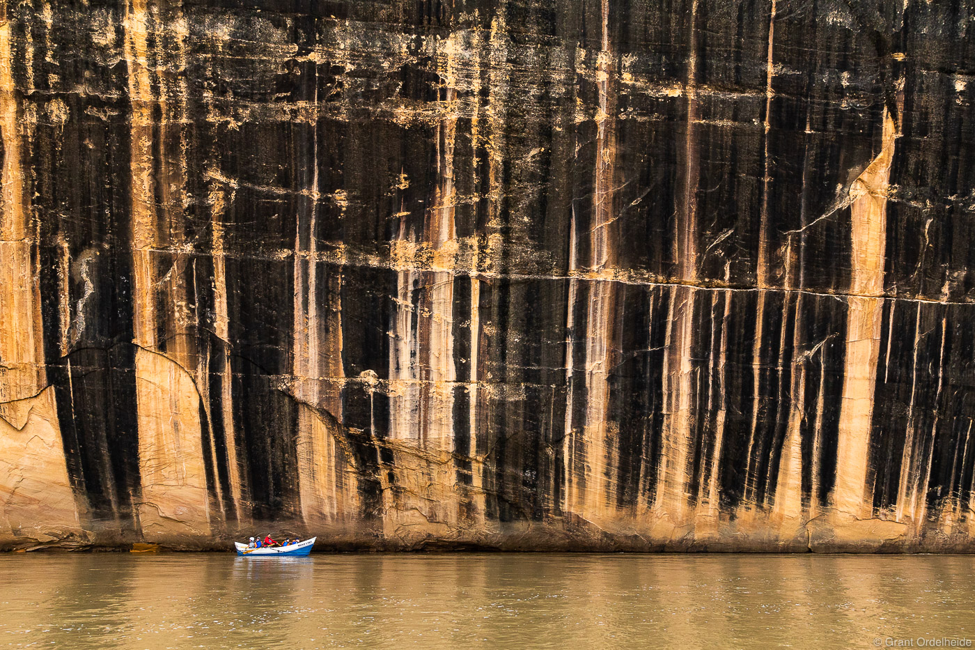 A dory boat passing below the Tiger Wall, a feature along the Yampa River in Dinosaur National Monument.