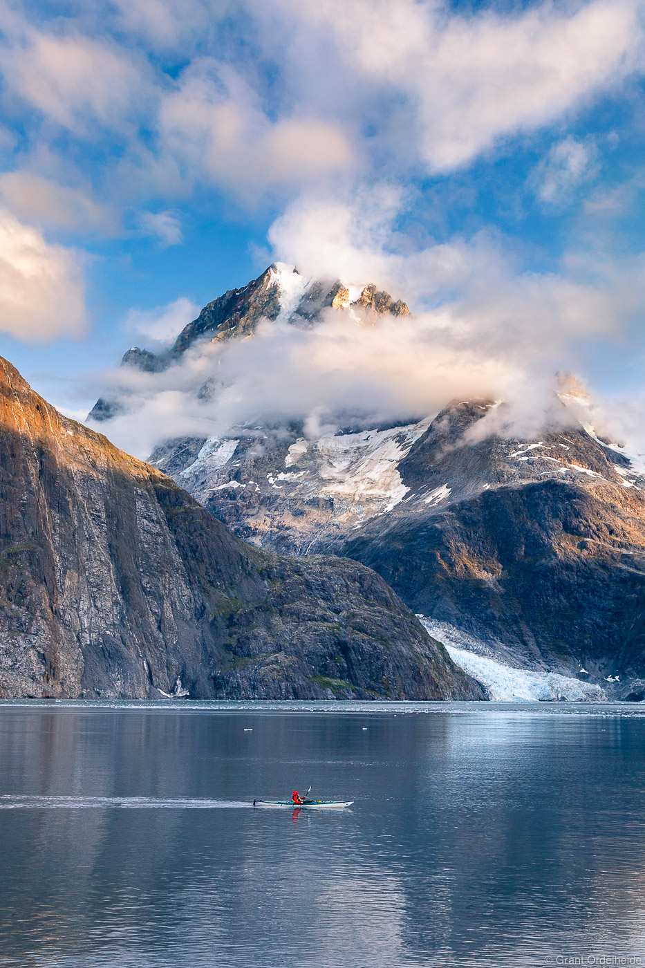 A kayaker paddling through Johns Hopkins inlet deep in Glacier Bay National Park.