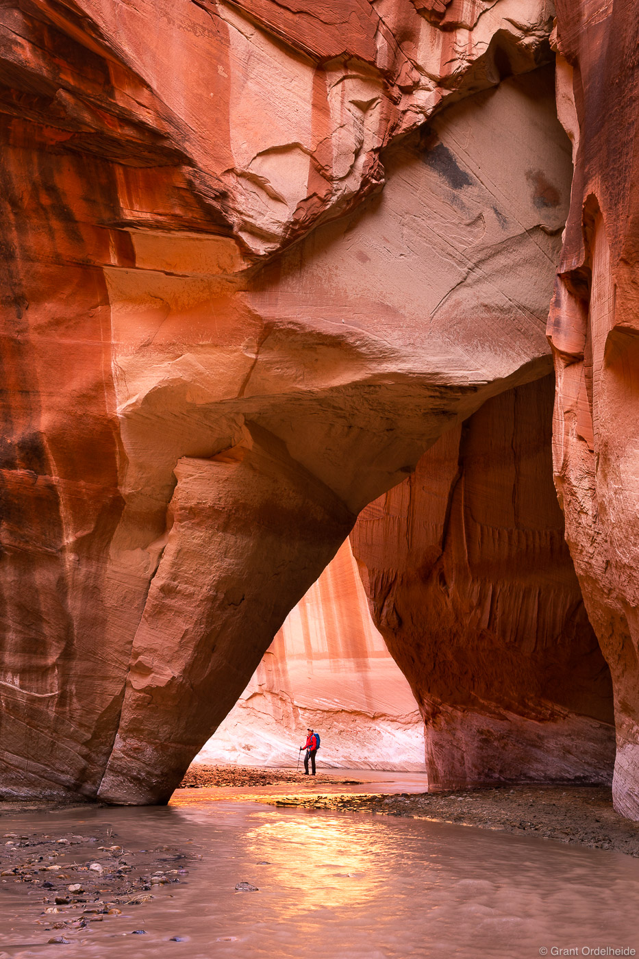 A hiker below Slide Arch deep in Utah's Paria Canyon.
