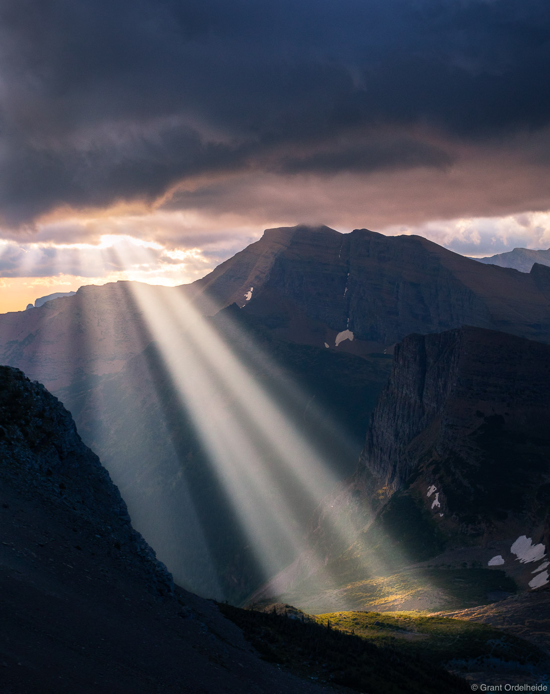 Early morning crepuscular rays shine down in the backcountry of Montana's Glacier National Park.