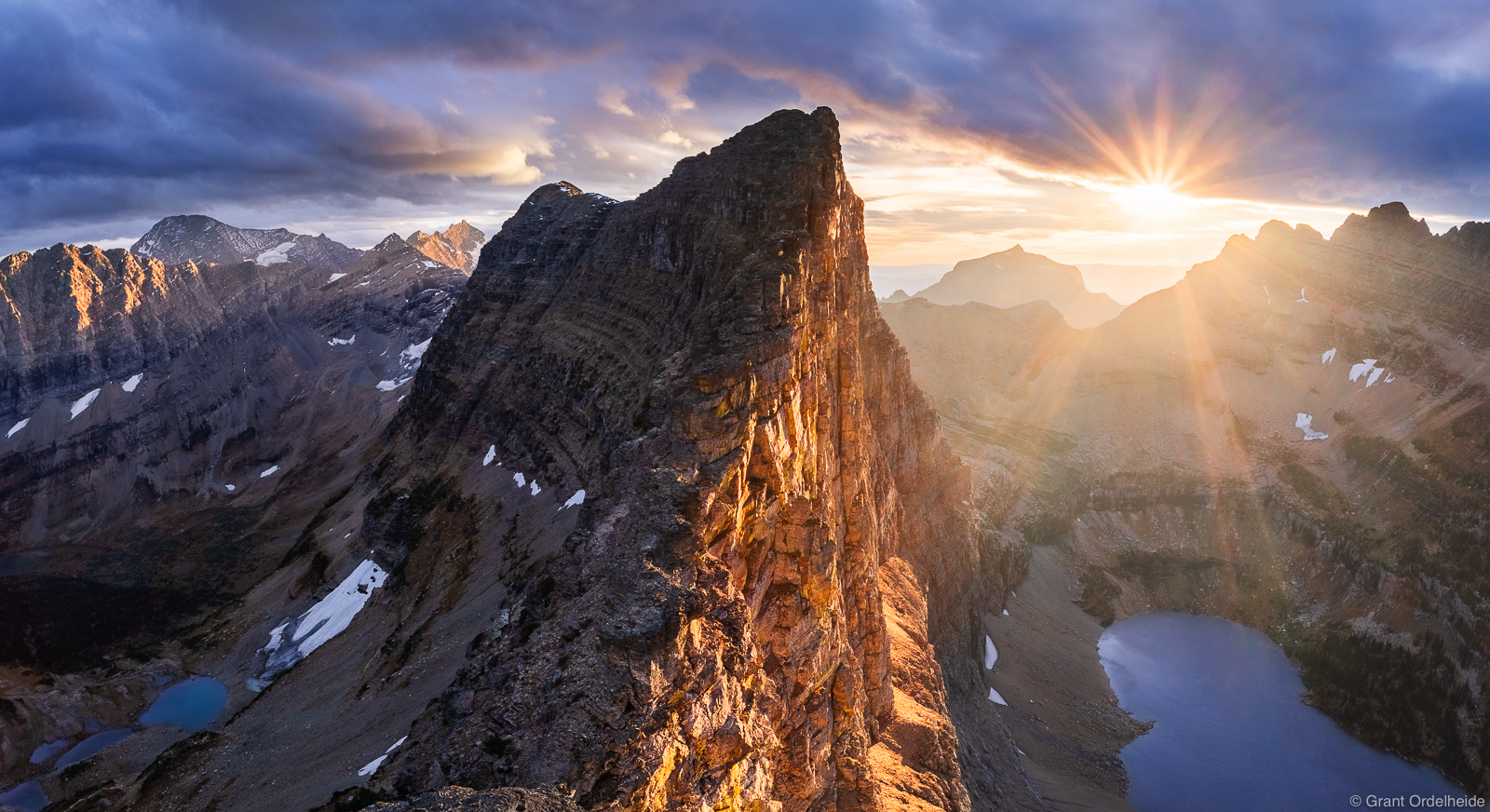 A stormy autumn sunset over the impressive Dragon's Tail formation in Glacier National Park.