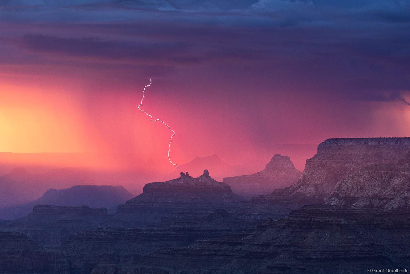A fiery sunset and thunderstorm converge over the Grand Canyon