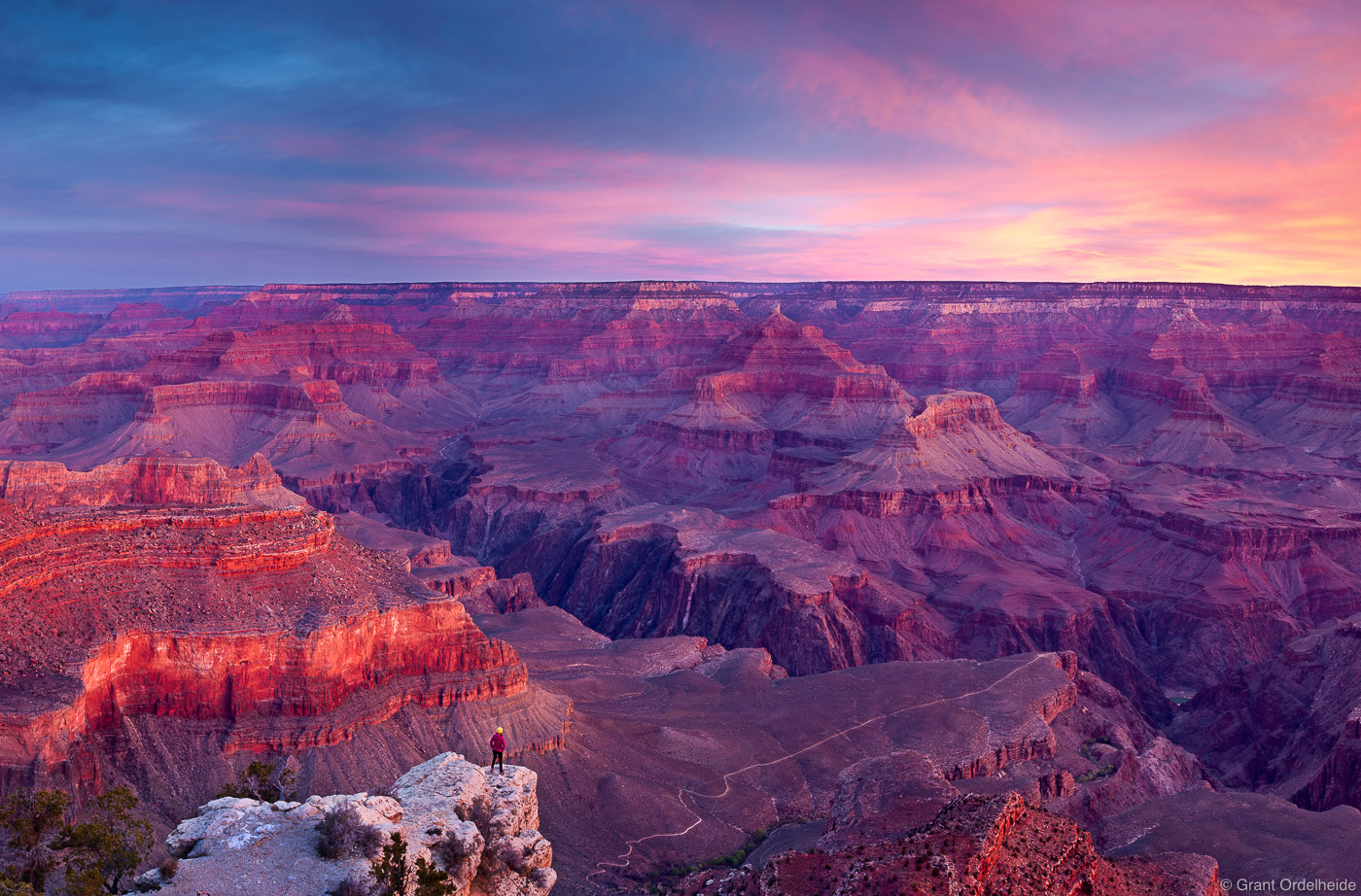 A person is dwarfed by the enormity of the Grand Canyon in Arizona