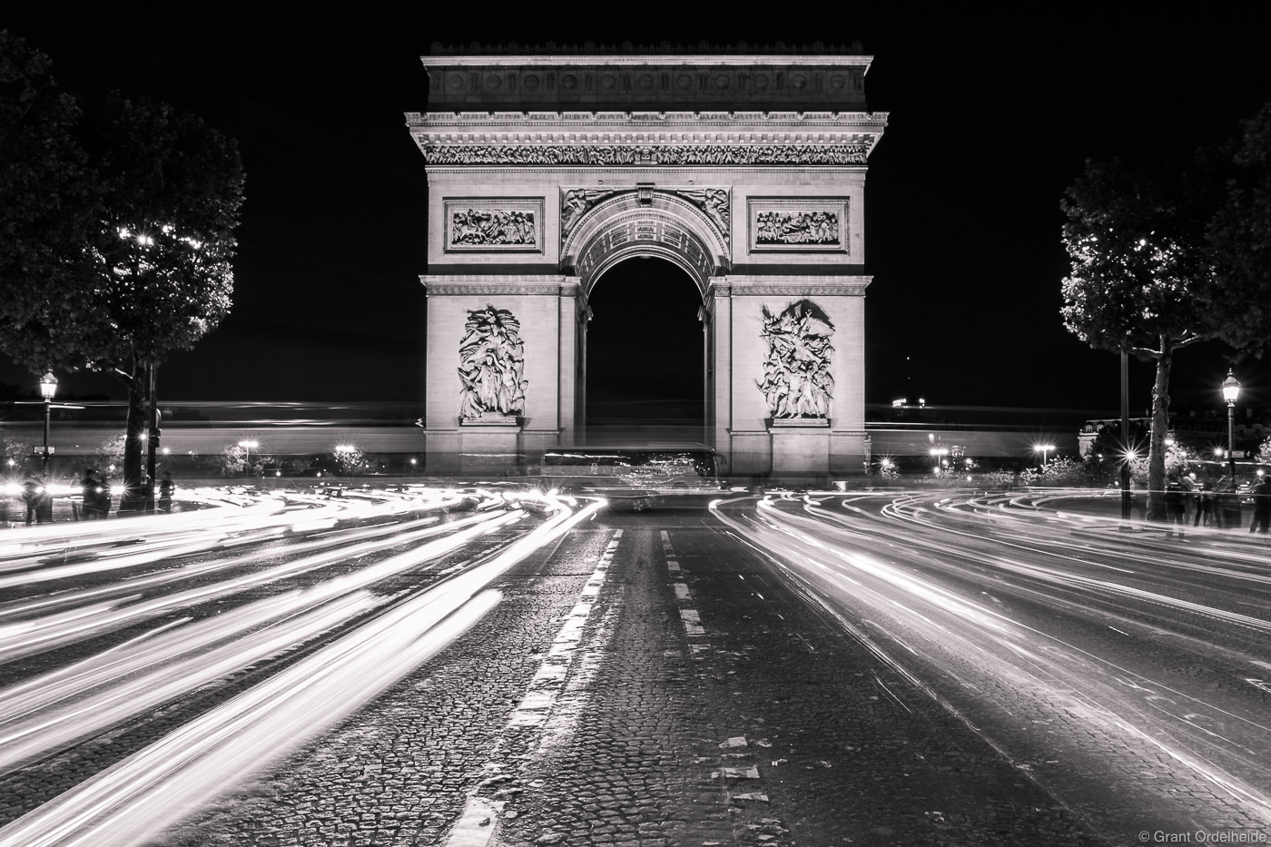 Car lights race around the famous arch.