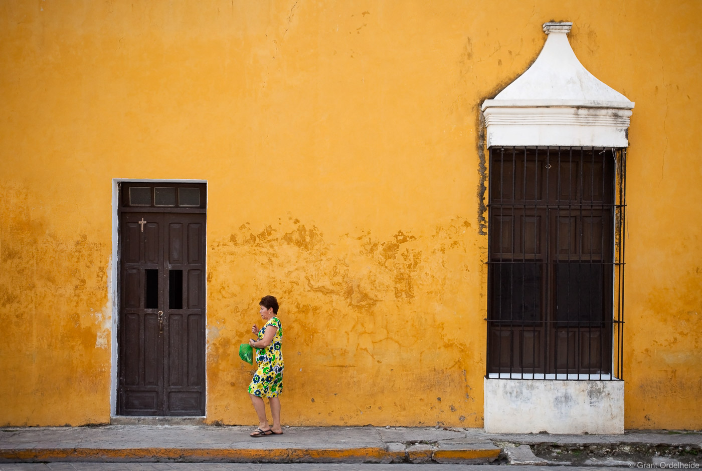 A woman walking down the street&nbsp;in the yellow city of Izamal.