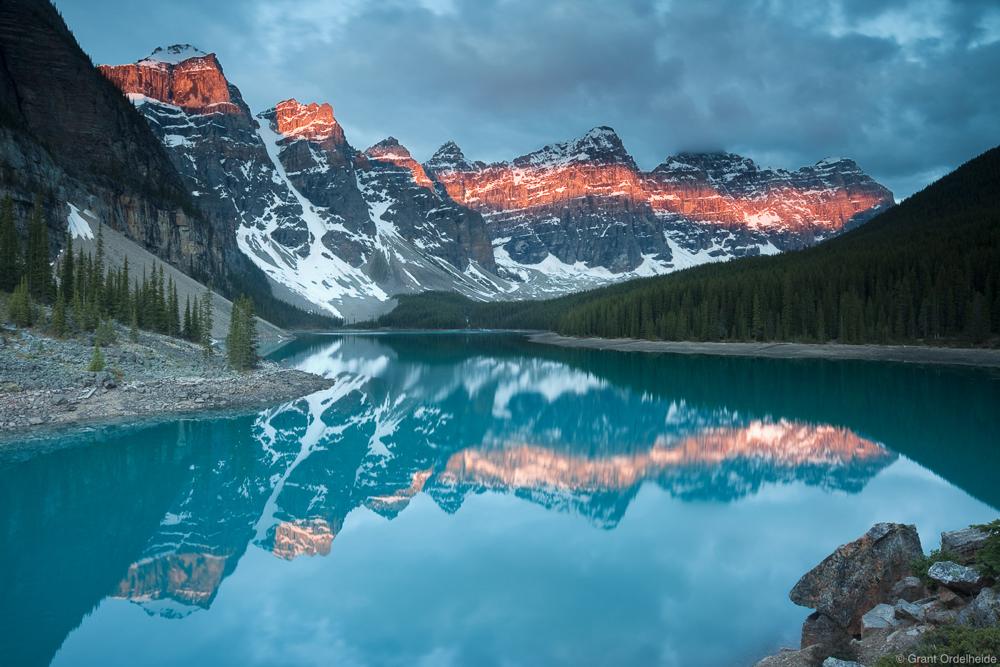 A dramatic sunrise on the iconic Moraine Lake in the Canadian Rockies.