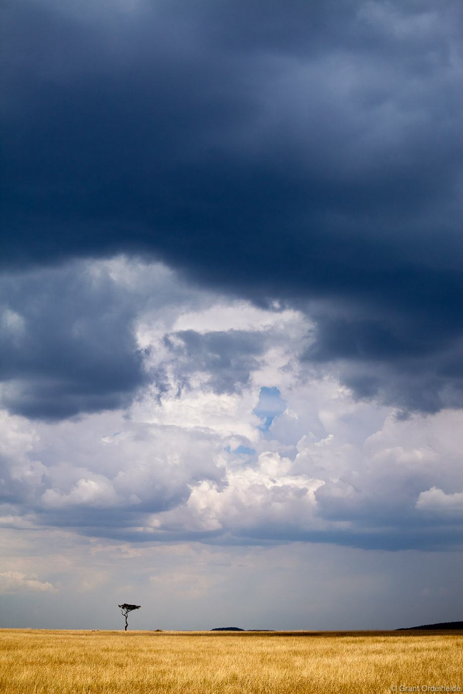 Brooding clouds form over the vast expanse of the Mara.