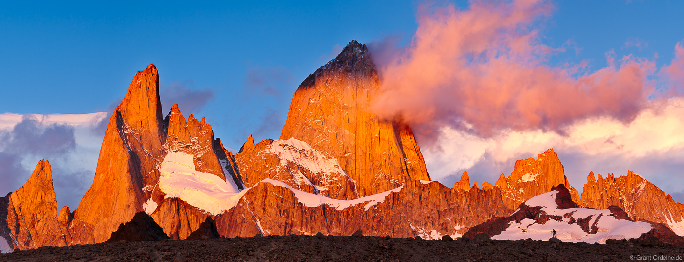 A lone hiker silhouetted agaisnt the massive Mount Fitzroy at sunrise.